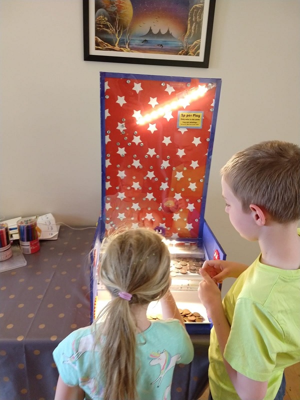 A red and blue arcade machine with Oliver and Elizabeth