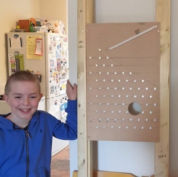 Oliver next to the backboard with screws in